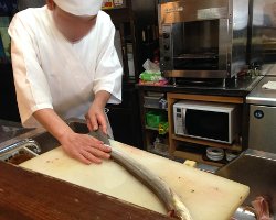 Foto cocinero limpiando anguila